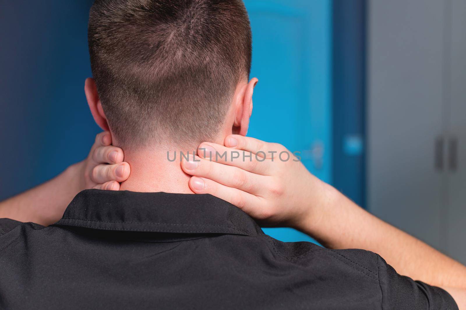 Young Caucasian male masseur doing self-neck massage to himself. Close-up. Myofasceal release.