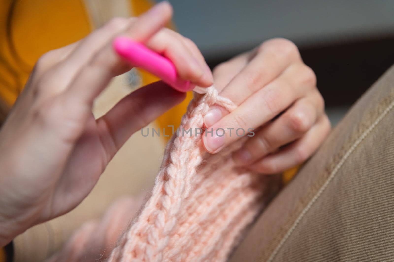 Close-up of young female hands of a Caucasian girl doing crochet, shows how to knit correctly. Shallow depth of field. high dynamic range