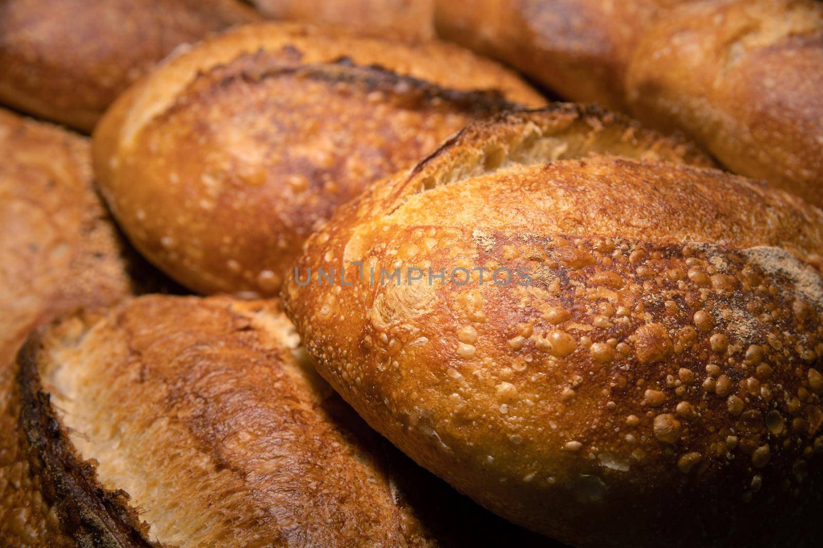 Appetizing fresh hot artisan bread. Close-up of a loaf of delicious bread on a wooden pallet.