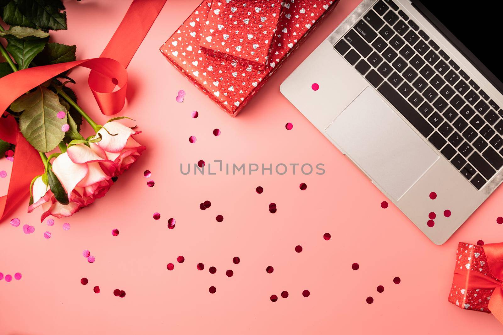 top view of valentines day workspace with laptop keyboard, flowers and gift boxes by Desperada