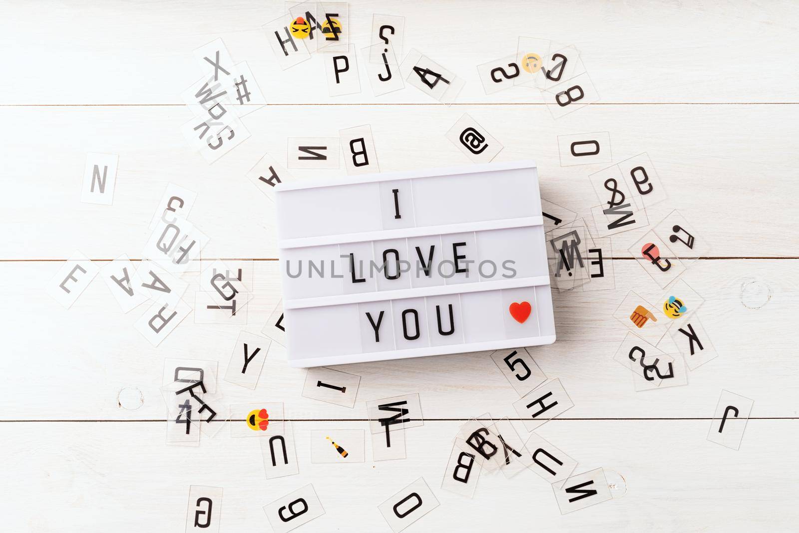 i love you words on a lightbox top view with scattered plastic letter on white background by Desperada