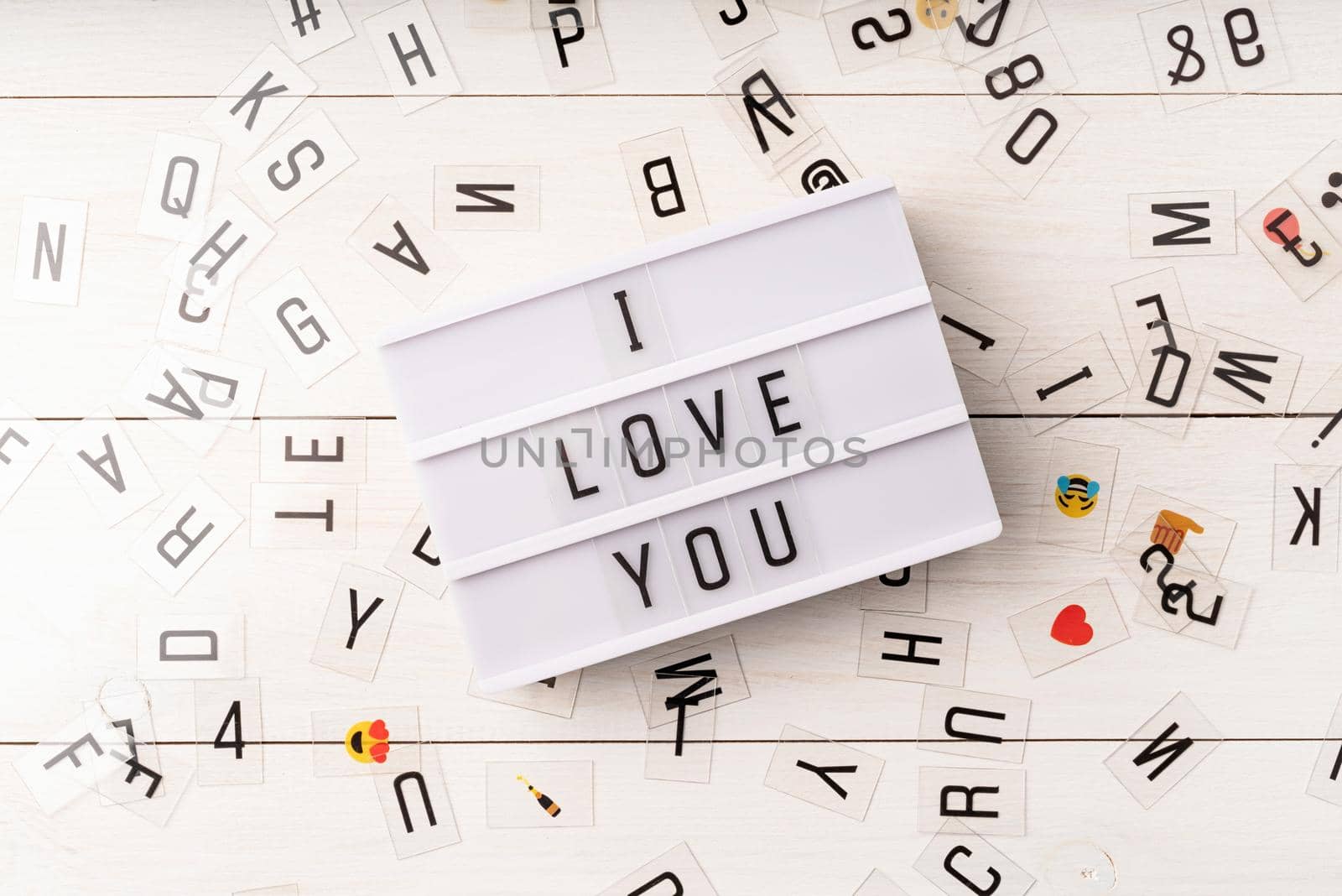 Valentines Day. i love you words on a lightbox top view with scattered plastic letter on white background