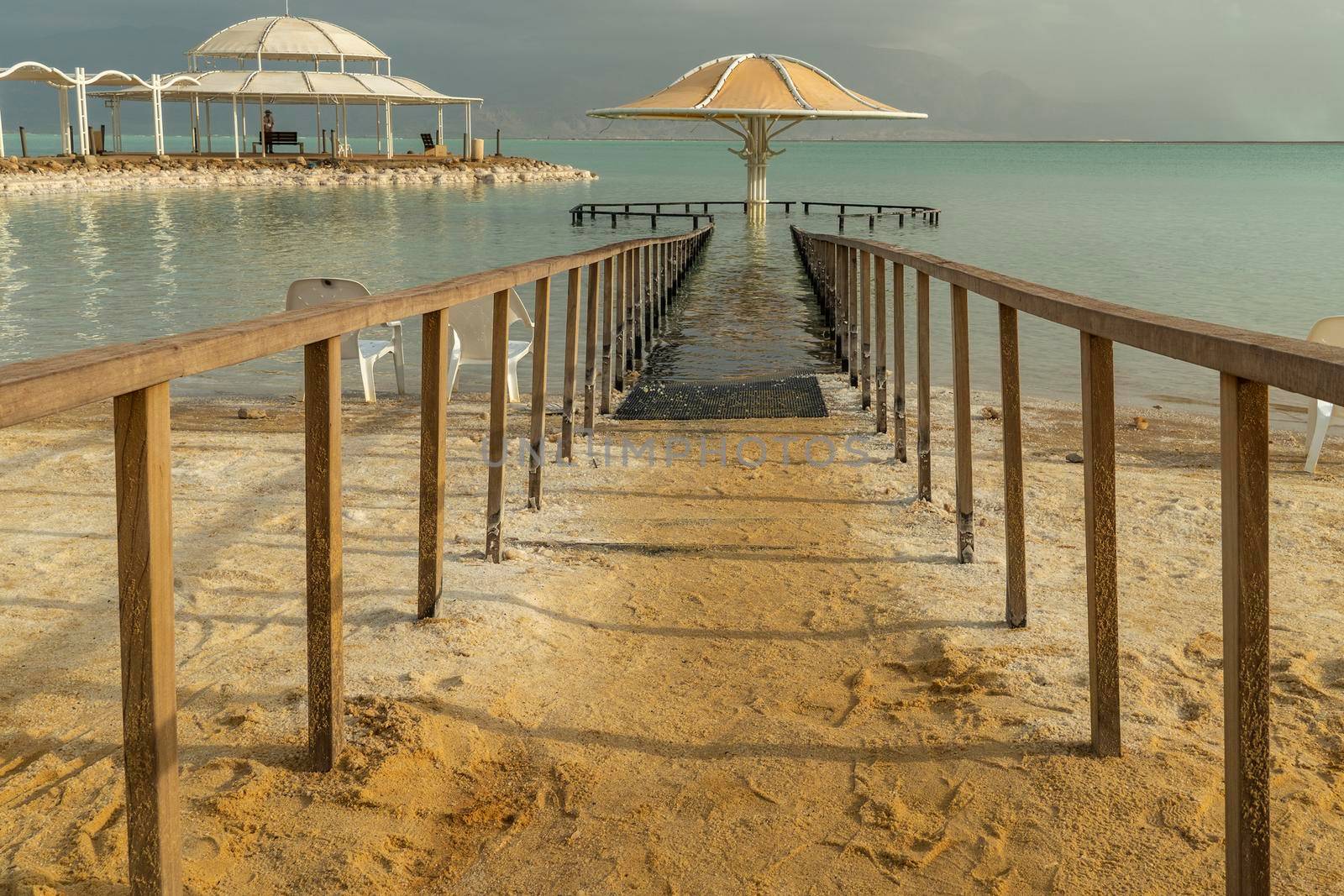 Fenced off with a wooden railing, the entrance leading to the canopy into the water of the Dead Sea
