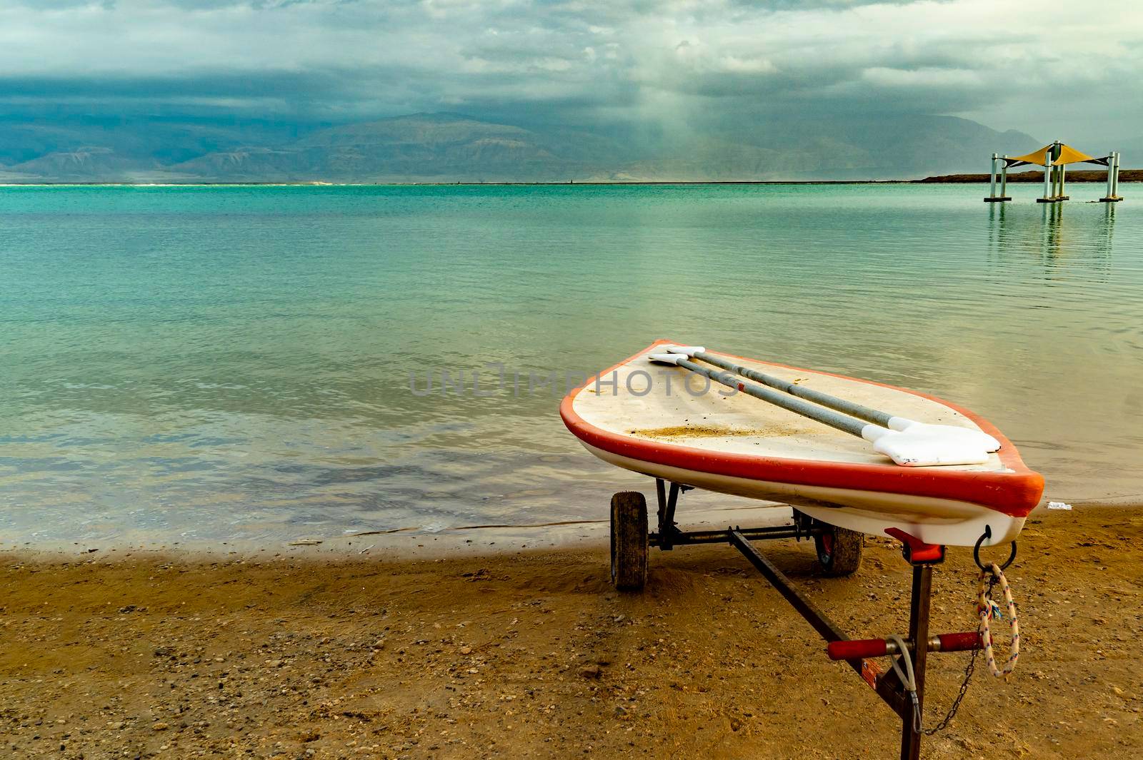 A lifeguard boat stands on wheels on the shore of a deserted beach