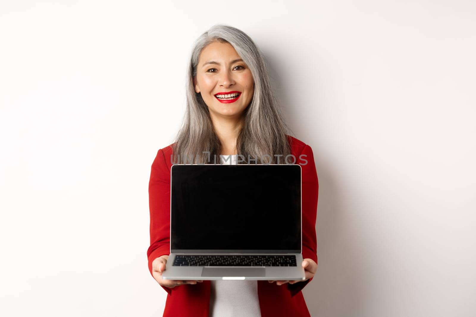 Business. Smiling asian businesswoman showing blank digital tablet screen, standing over white background by Benzoix