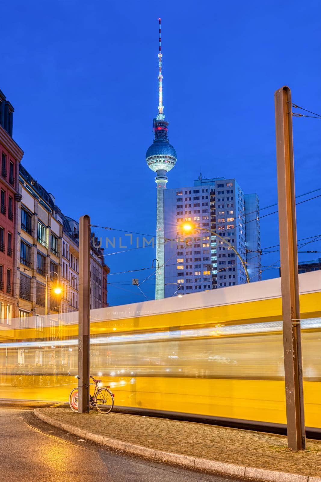 The famous TV Tower in Berlin at night with a moving tramway