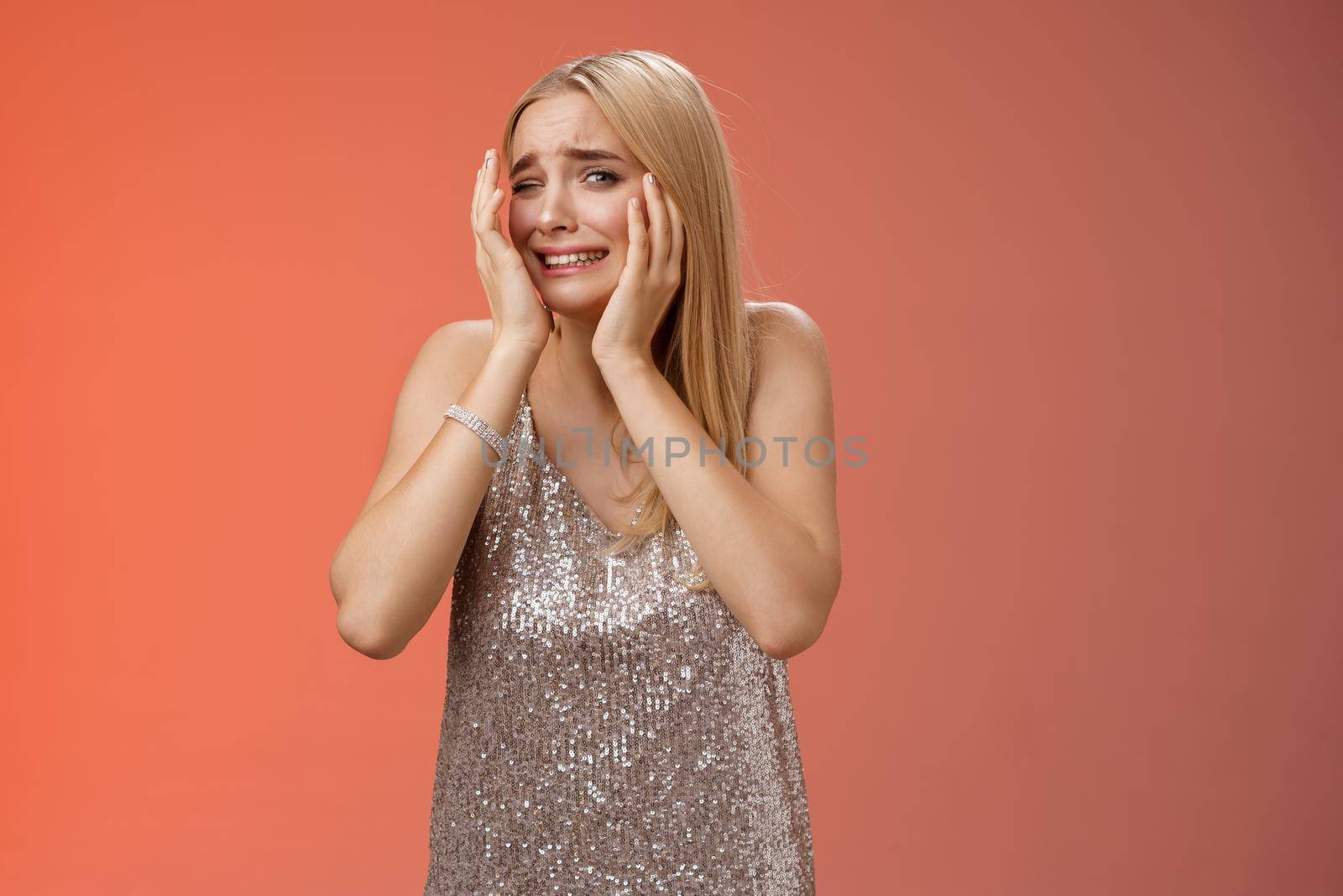 Concerned blond girlfriend panic feel afraid insecure unsafe anxiously turning face cover head look lost frightened assault victim in nightclub scared standing terrified in silver dress.