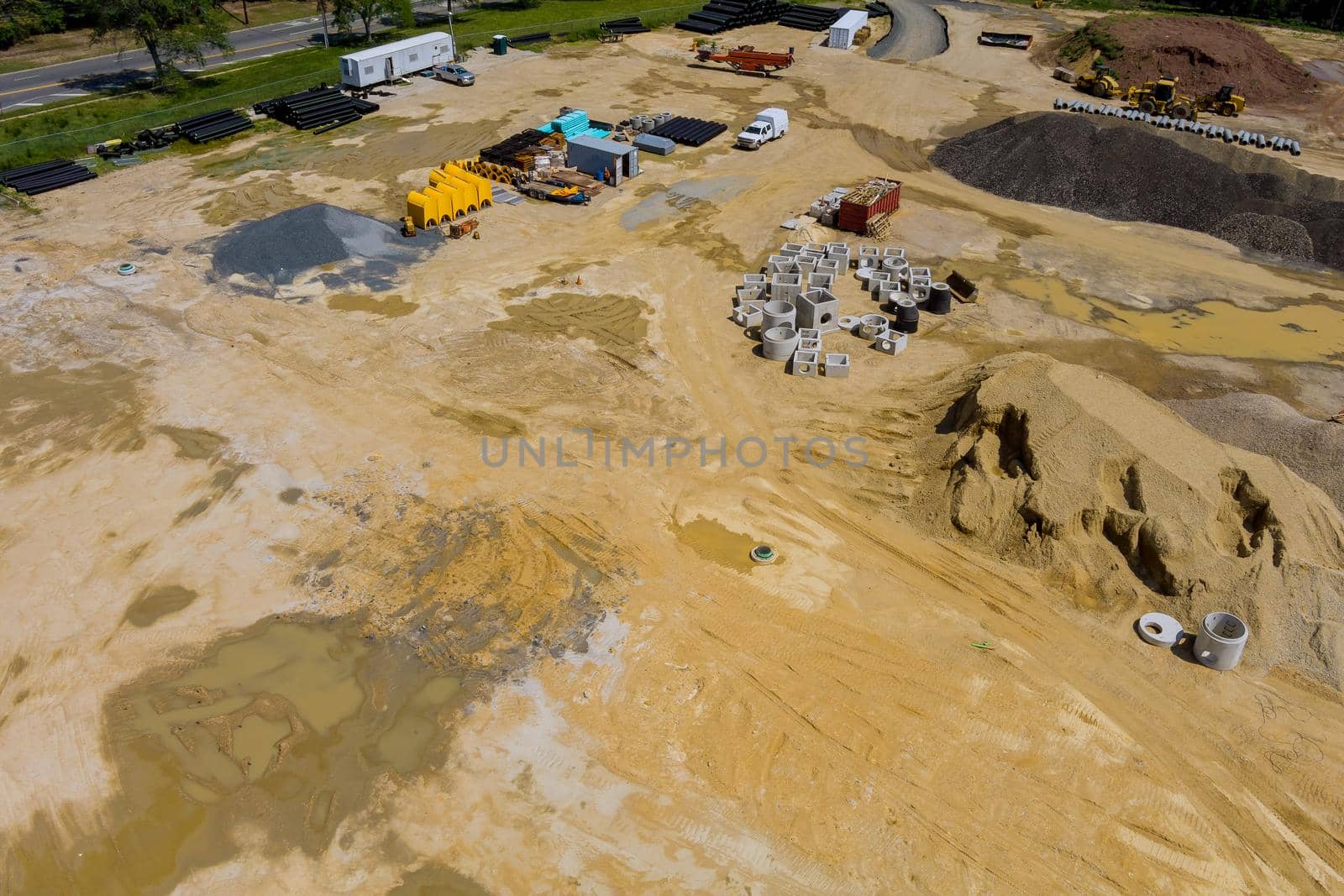 Aerial view of preparation for installation works pipes for sewage drainage are stacked neatly on the ground.