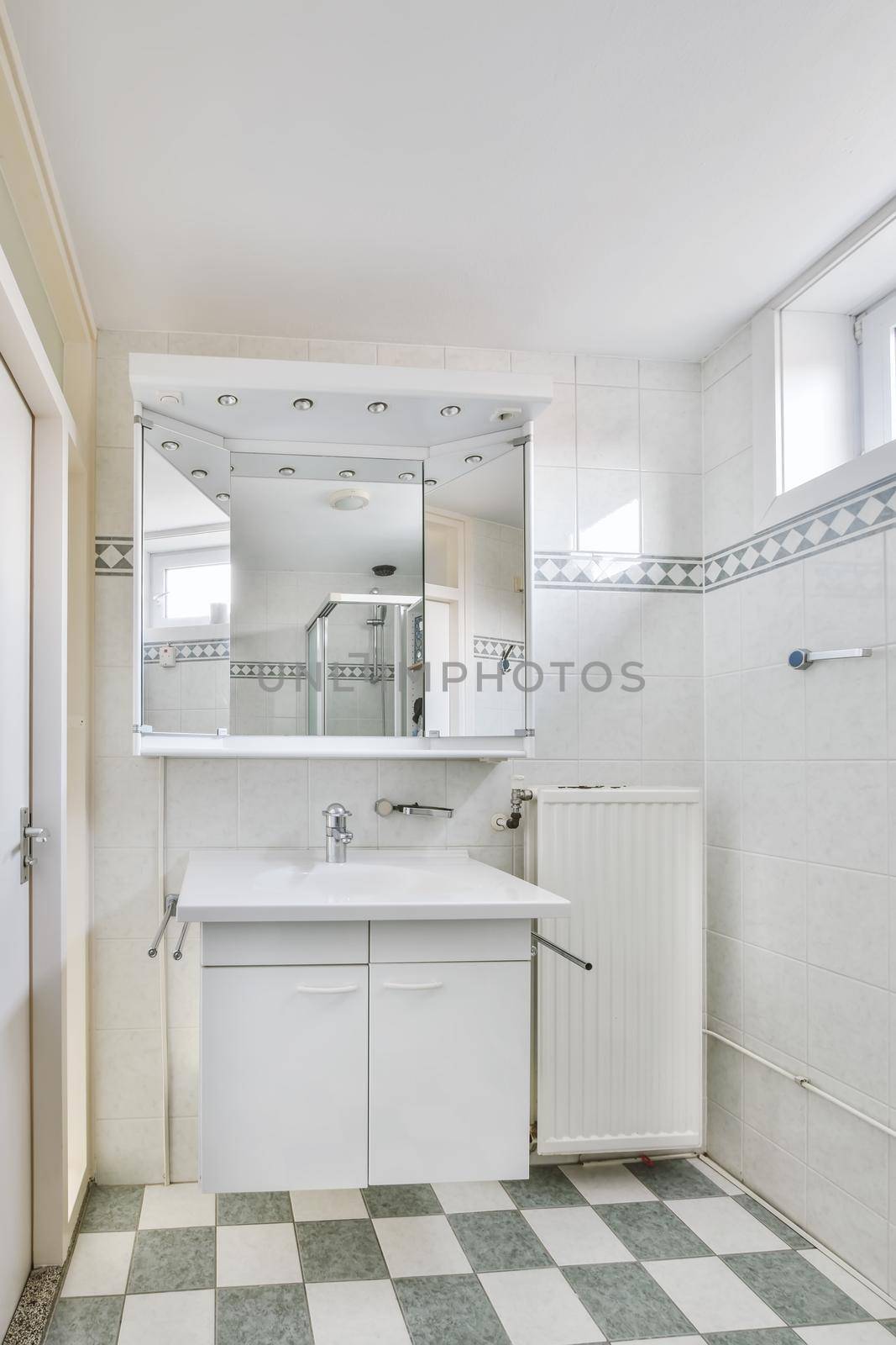 Small bathroom interior with white cabinets, granite countertops and toilet.