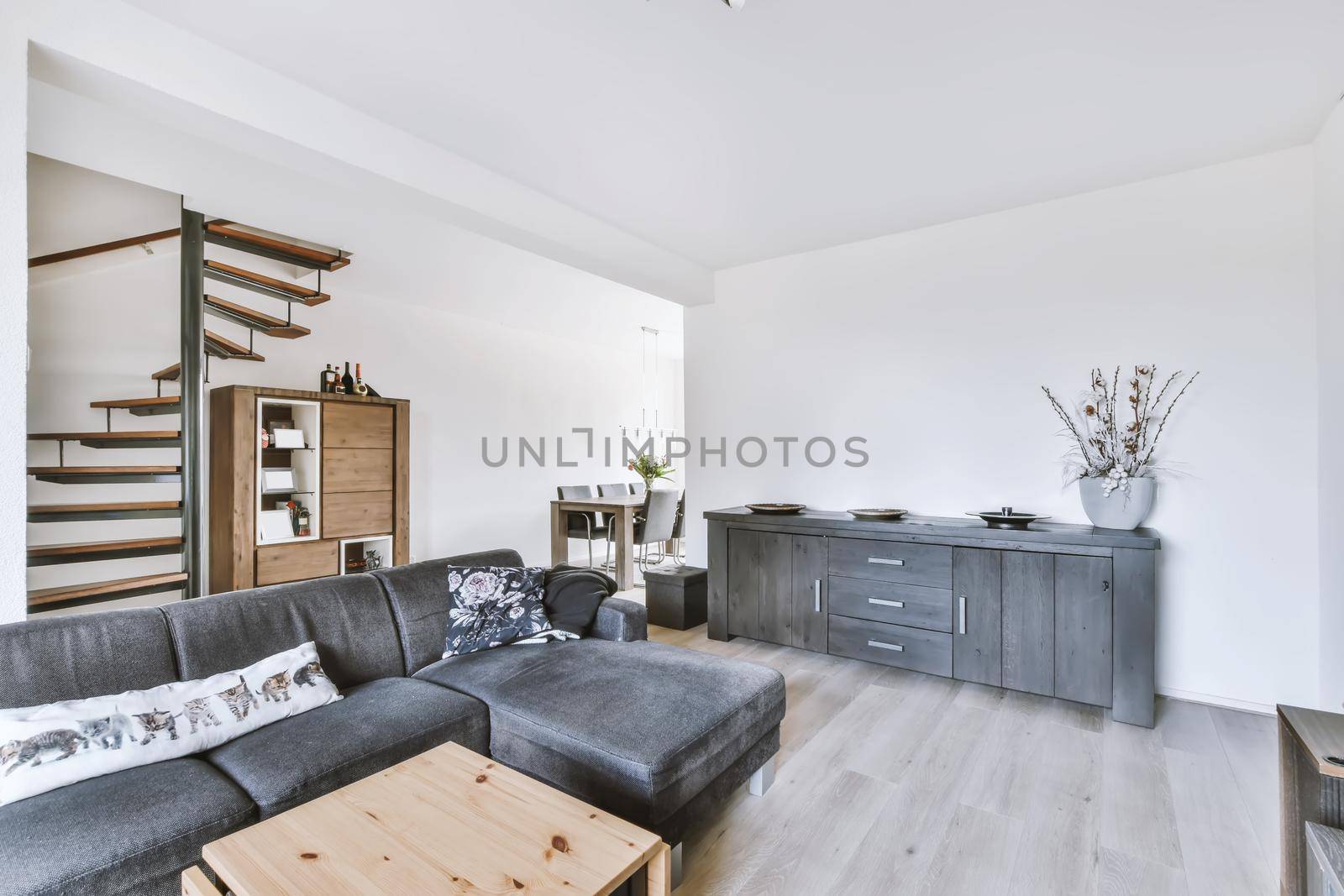 The living room interior in bright colors, gray sofa over a light parquet floor