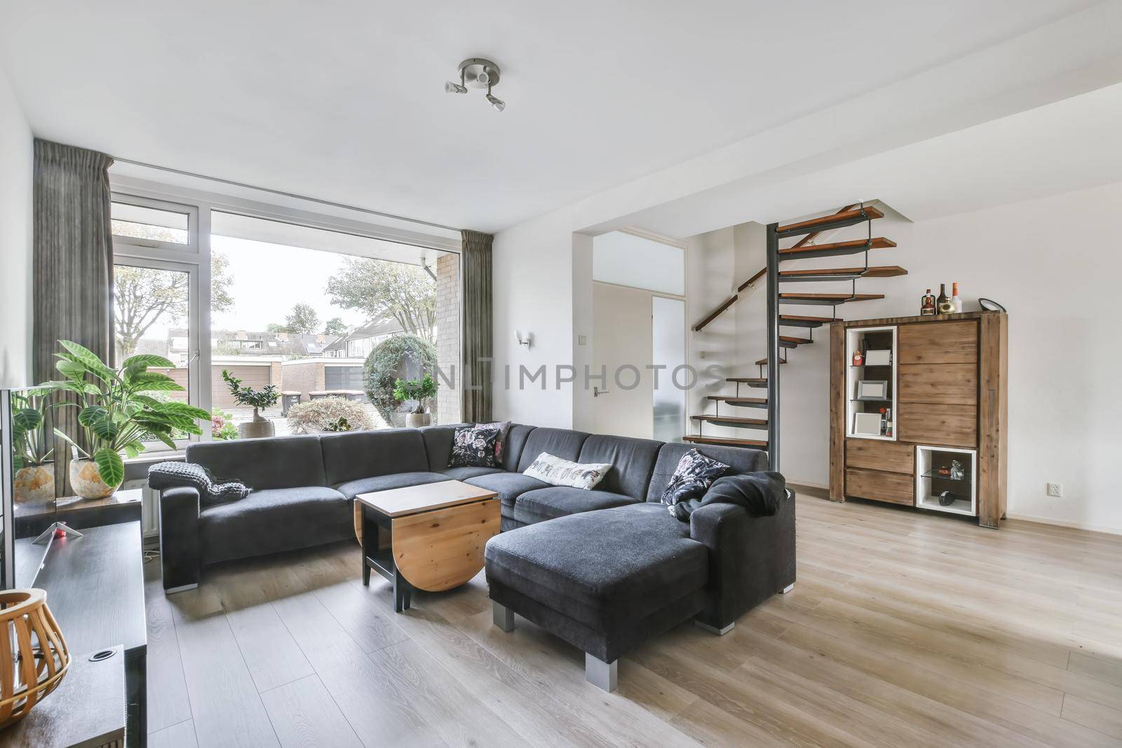 The living room interior in bright colors, gray sofa over a light parquet floor