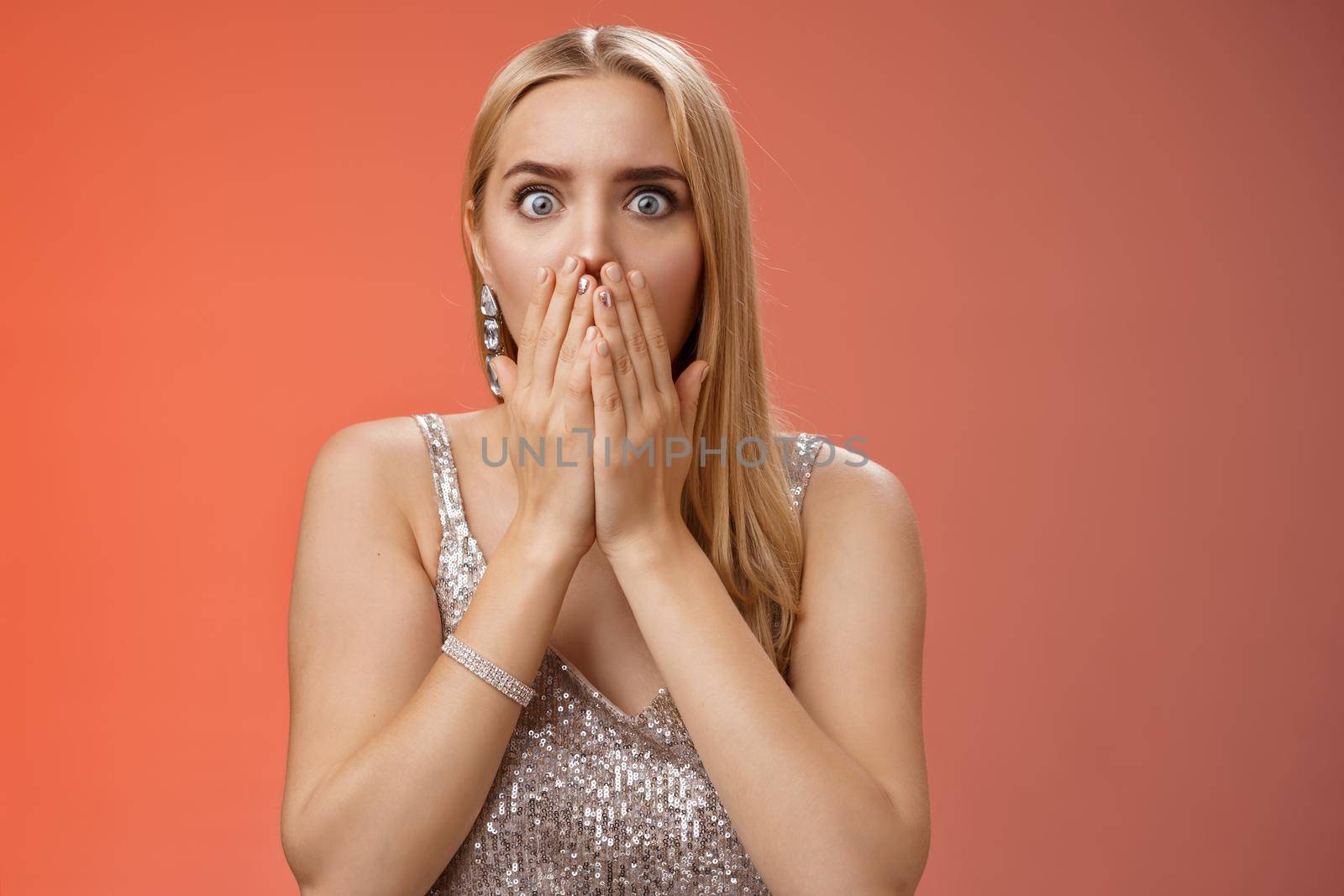 Concerned shocked worried blond woman terrified gasping cover mouth hands pray gesture widen eyes witness terrible accident worry expressing empathy pity, standing red background uneasy.