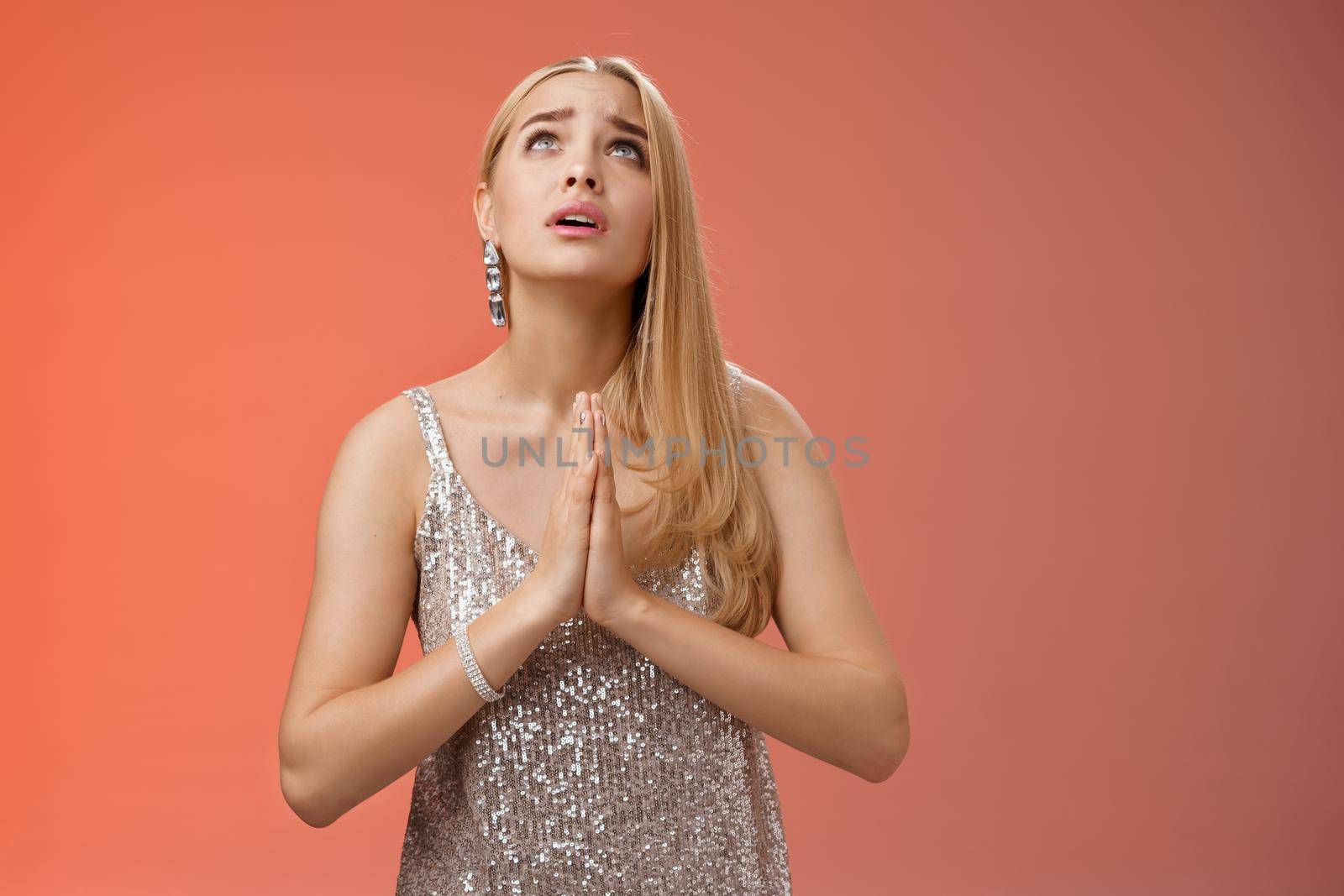 Hopeful worried concerned faithful blond woman in silver dress praying talking god wishing family okay press palms together supplicating nervously begging, standing red background stylish dress by Benzoix