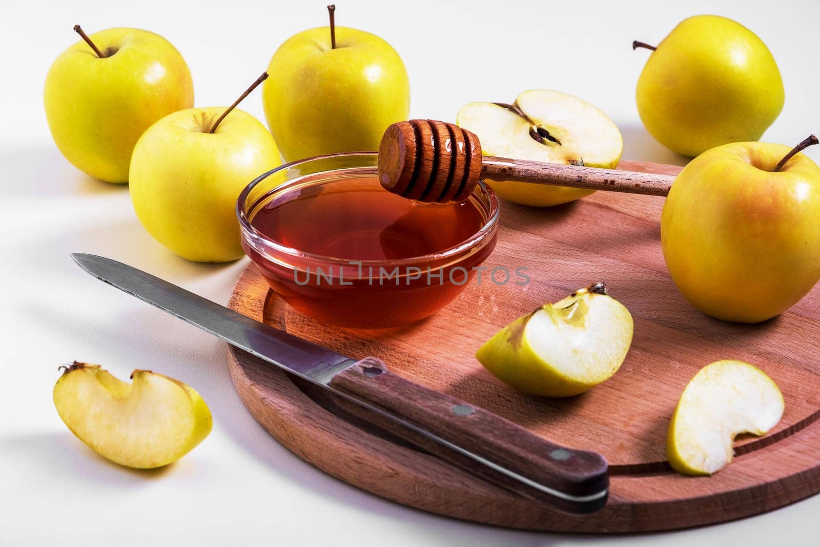 Fresh ripe whole and cut yellow apples with honey lie on table. Selective focus.