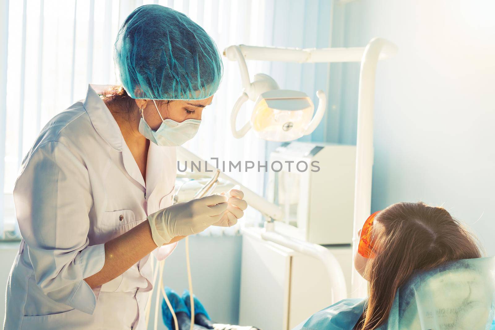 A young female dentist and a patient.
