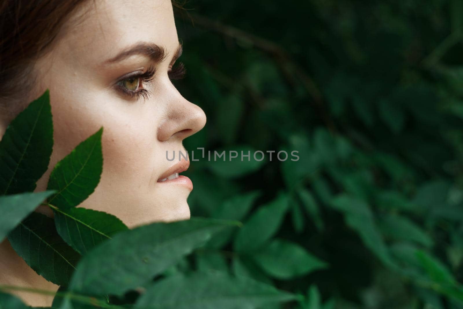 smiling woman Cosmetology nature green leaves glamor close-up. High quality photo