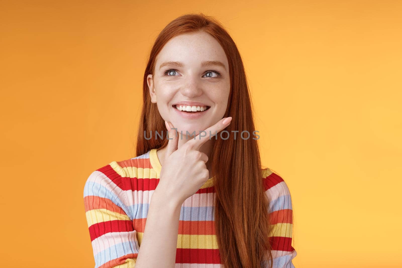 Creative satisfied smart redhead girl got excellent idea touching chin smiling broadly delighted good thought look upper left corner thinking pondering made up choice wanna implement plan by Benzoix