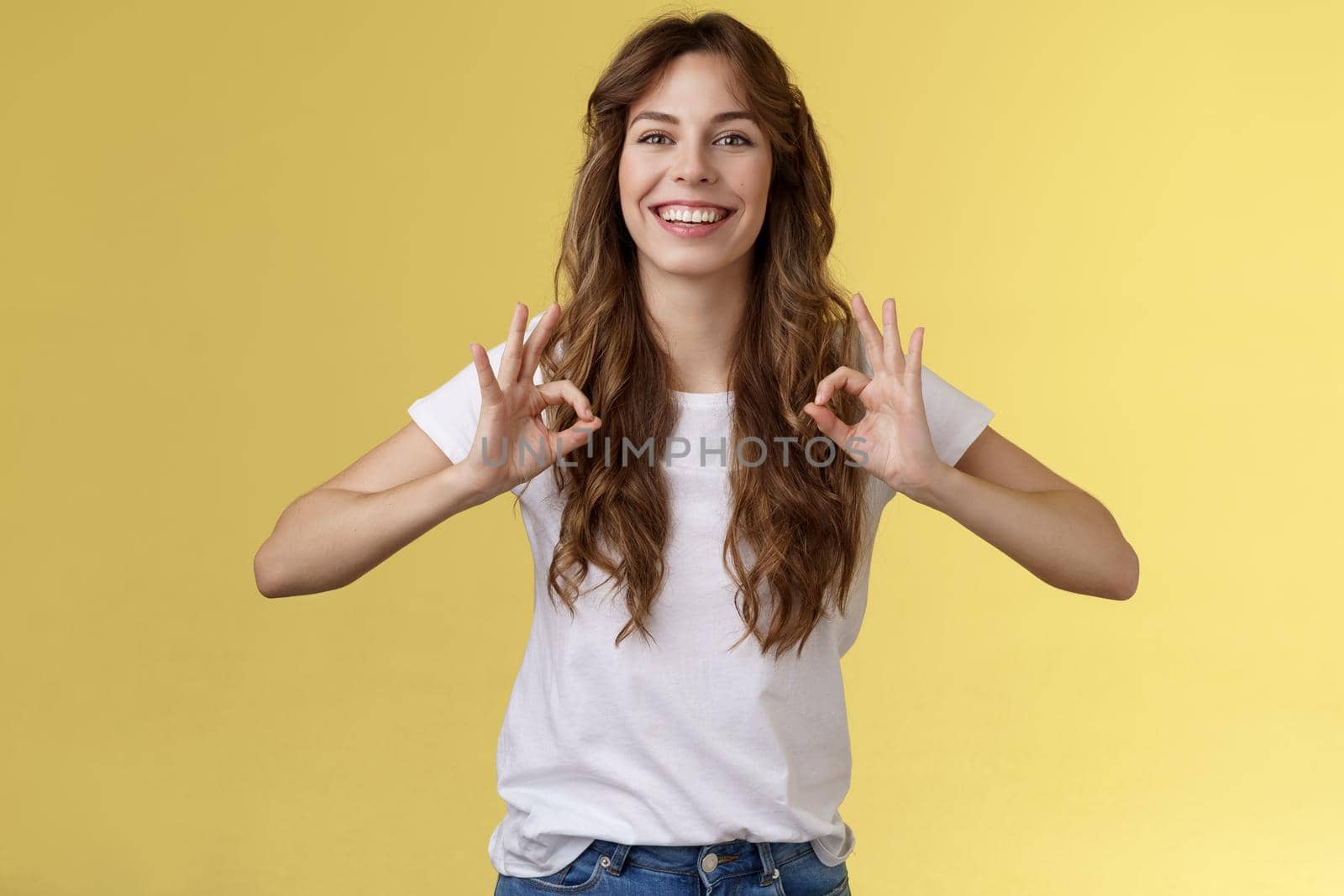 Deal I guarantee excellent results. Good-looking friendly pleasant young woman assure everything okay show ok perfect gesture smiling confident relaxed stand yellow background promise be good.