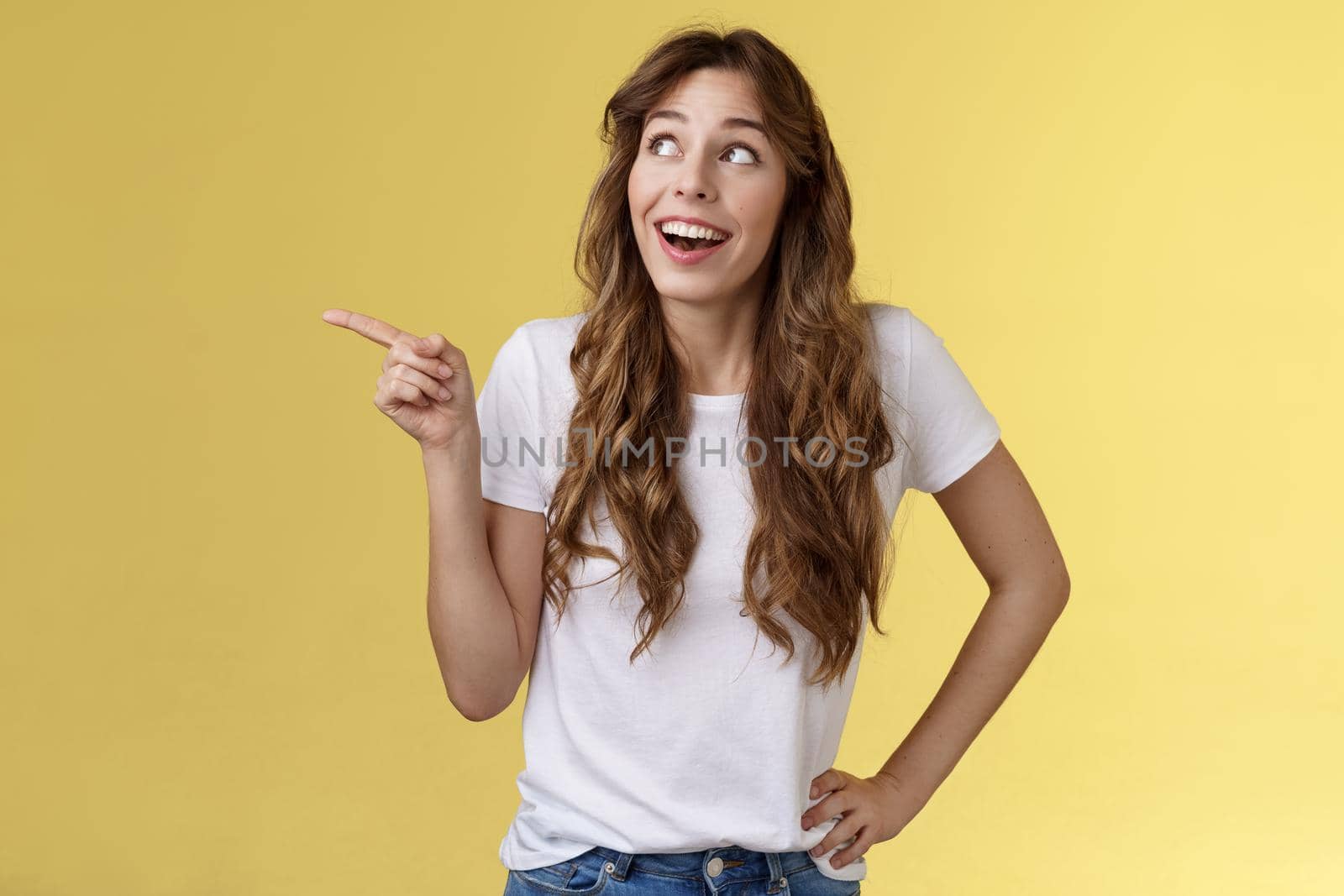 Wondered impressed charismatic fascinated smiling happy girl pointing look upper left corner speechless surprised grinning toothy happiness joy expression contemplate great view yellow background by Benzoix
