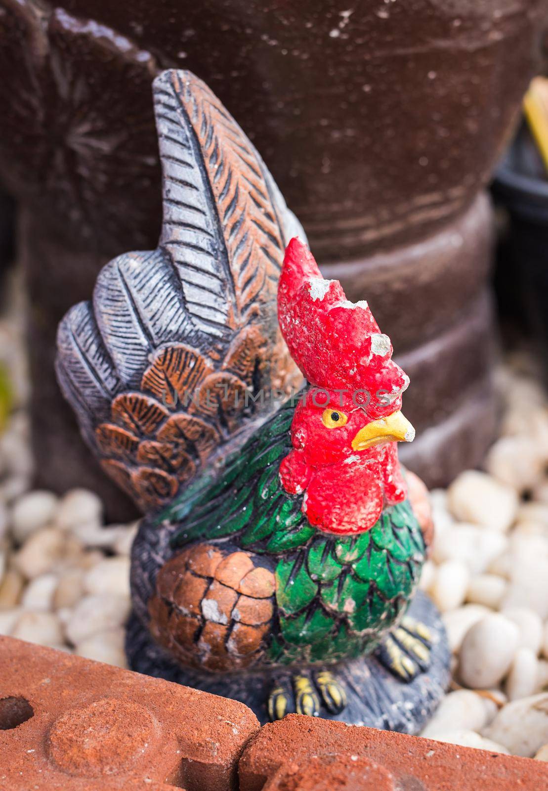 Rooster Figurine outdoors. statue of a rooster in a garden