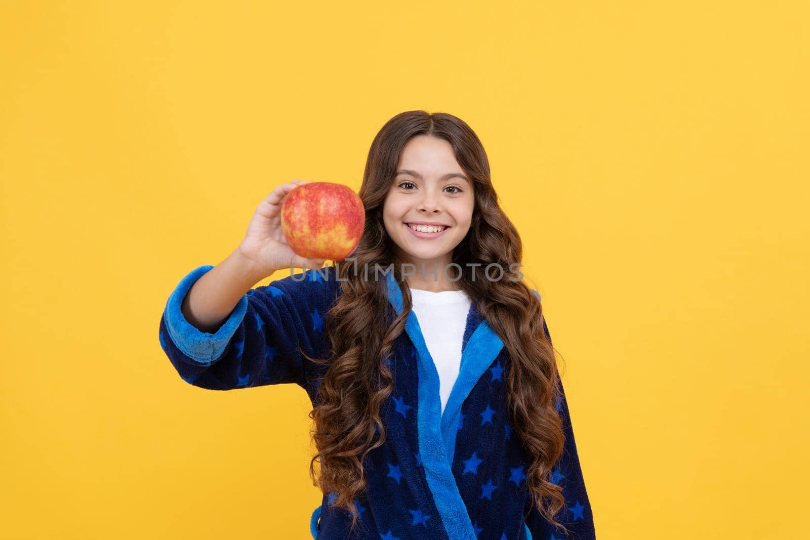 happy child girl enjoy morning breakfast of fresh apple in cozy bathrobe, organic food by RedFoxStudio