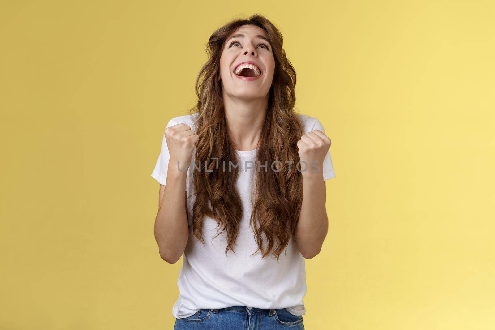 God finally yes. Relieved thankful pleased happy girl look up thank god fist pump celebration success win triumphing clench arms grateful delighted lucky opportunity stand yellow background by Benzoix