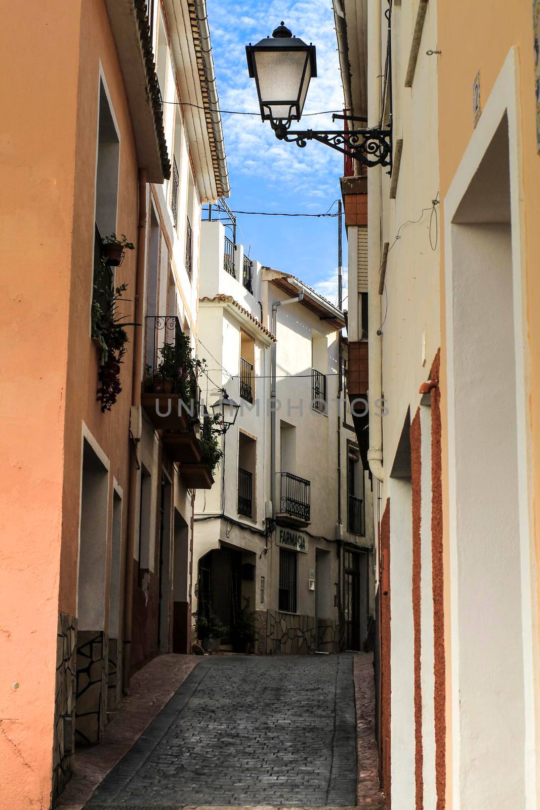 Beniarda, Alicante, Spain- November 26, 2021: Narrow Street and typical whitewashed facades of the town of Beniarda in Alicante, Spain