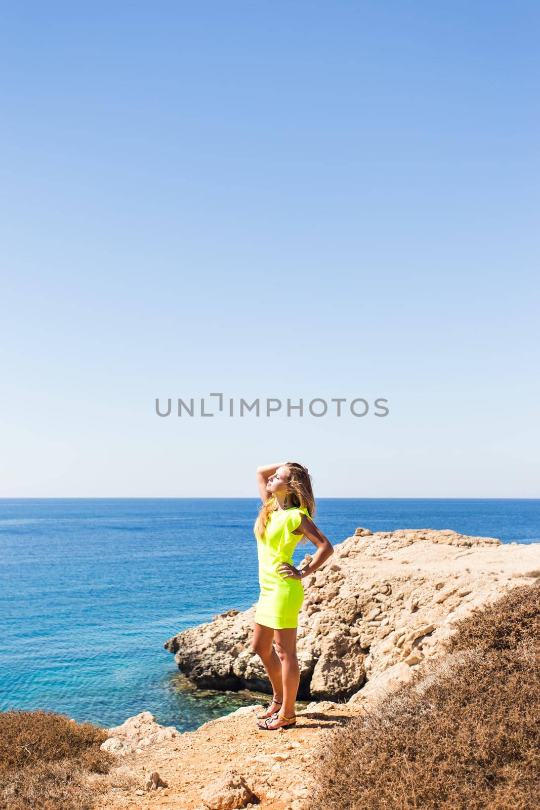 young beautiful caucasian female on a cliff above the sea.