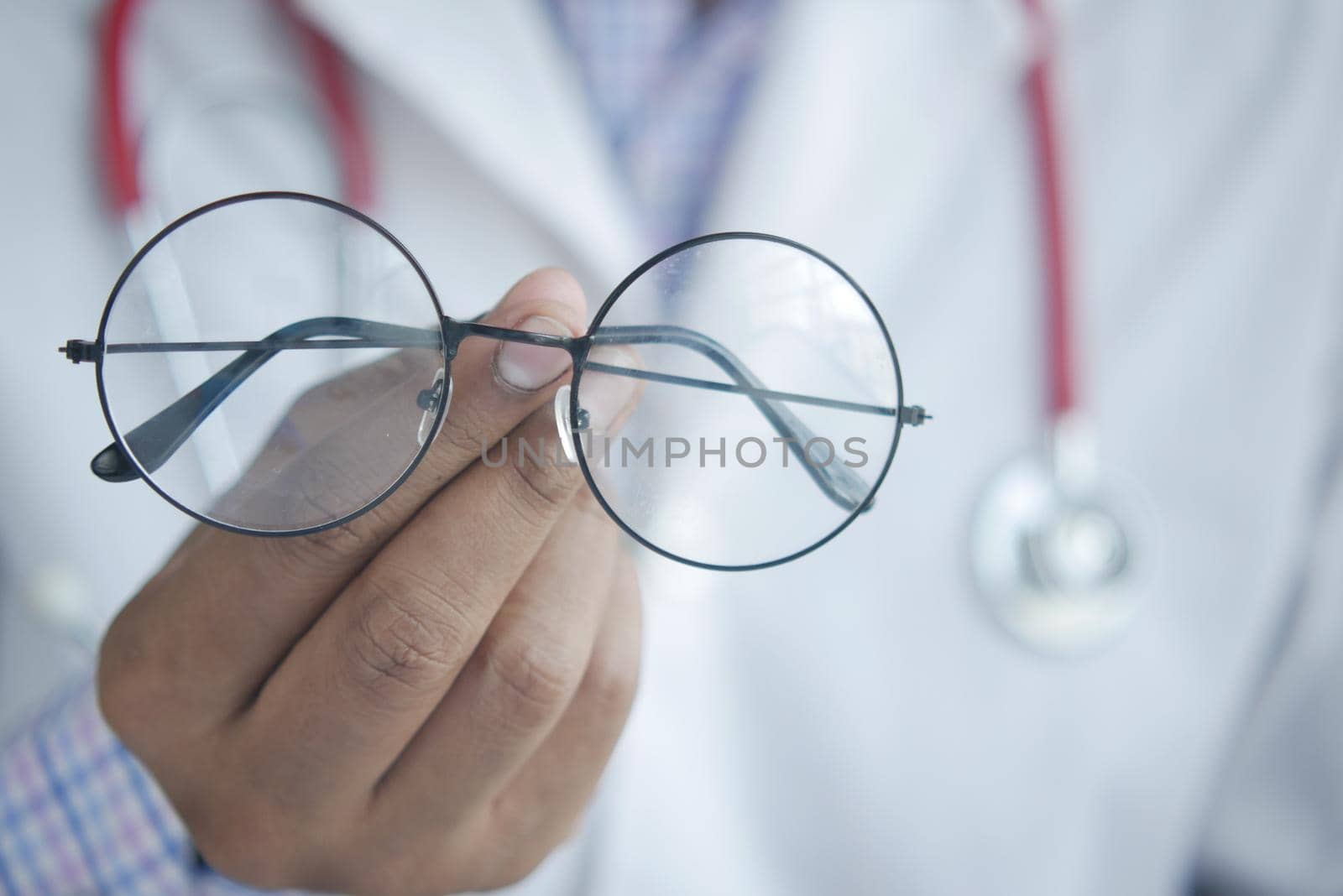 doctor hands giving pair of black glasses to patient