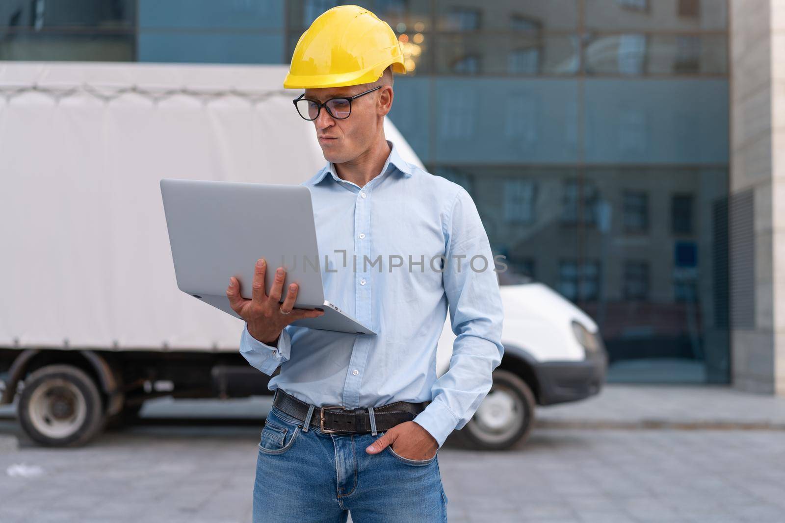 Business. Engineer Worker Protective Helmet Use Laptop Controls Working Process Inspector Supervisor Yellow Hard Hat Glasses Transportation Company by andreonegin