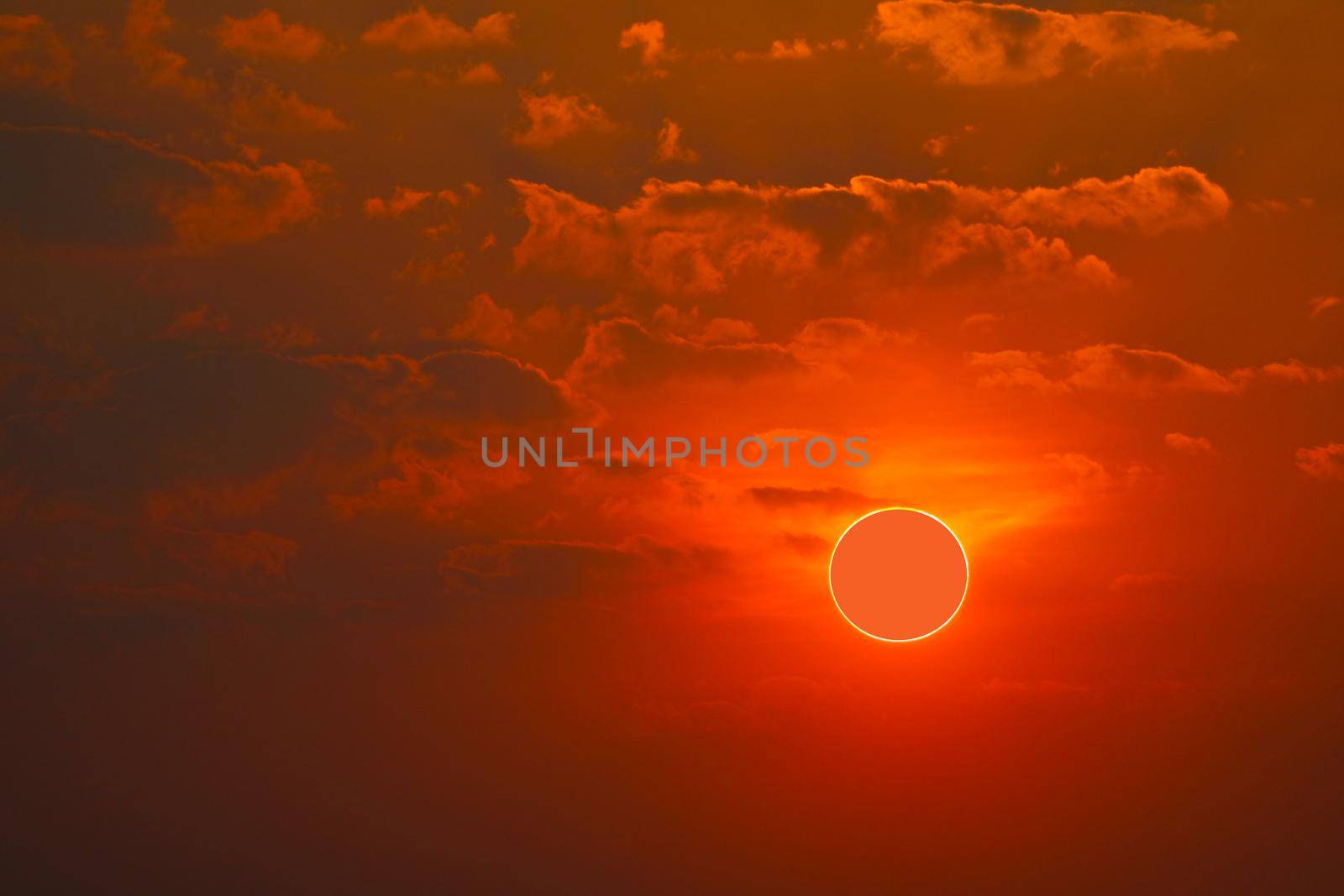 phenomenon of partial sun eclipse over sea and sunset sky