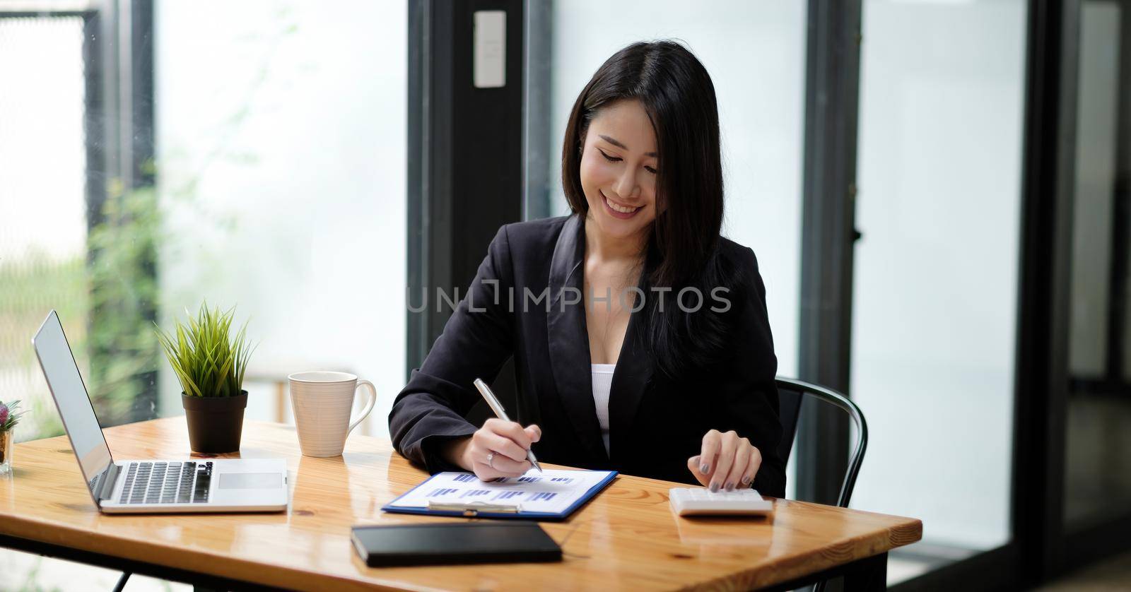 Business woman accountant working with computer and calculator for business and financial expense. Attractive asian girl working with laptop computer by nateemee