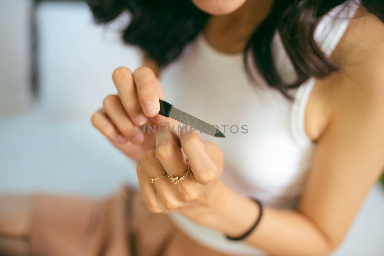 Portrait of a smiling pretty young woman painting friend's nails over white background by makidotvn