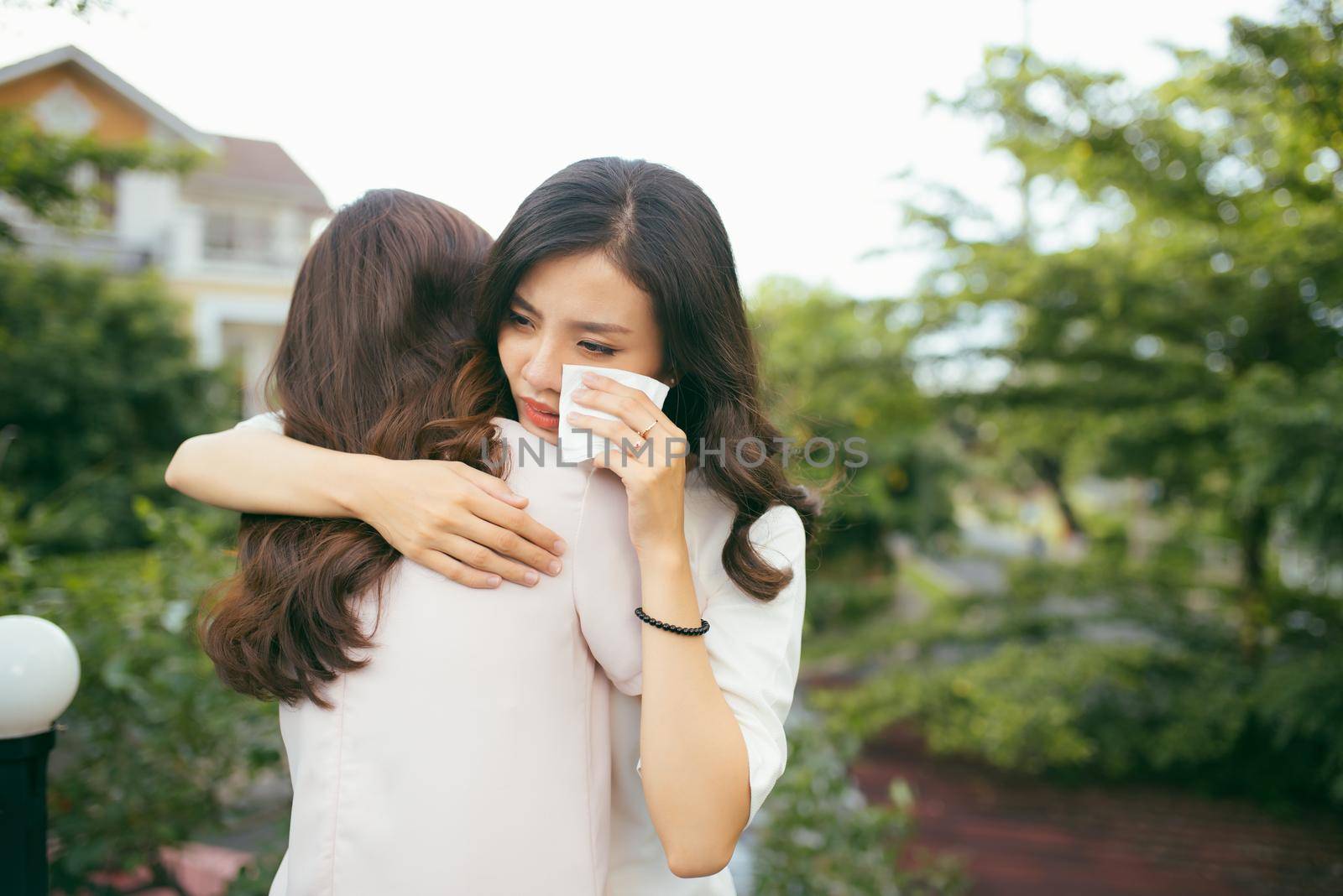 Portrait two women. Sad unhappy young woman being consoled by her friend. Friendship help support and difficult times concept. Human emotions feelings