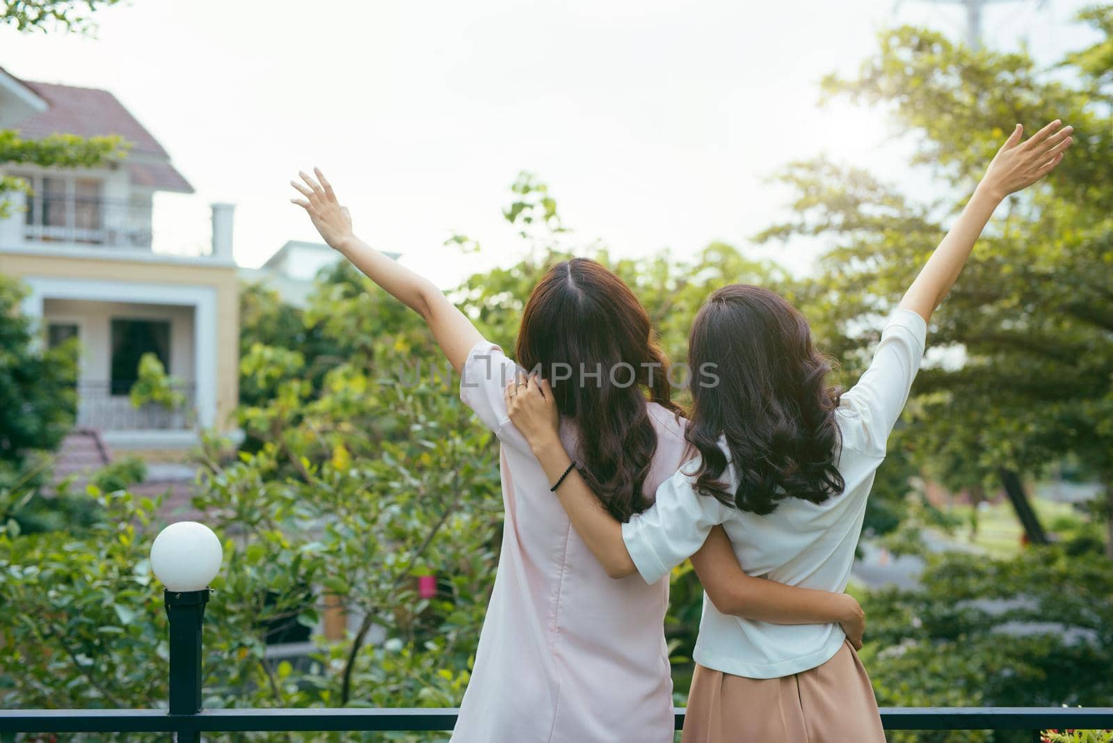 Outdoor fashion portrait of best girl friends posing back and hugs, both wearing stylish trendy hipster retro dresses. Enjoy their friendship and great time together.
