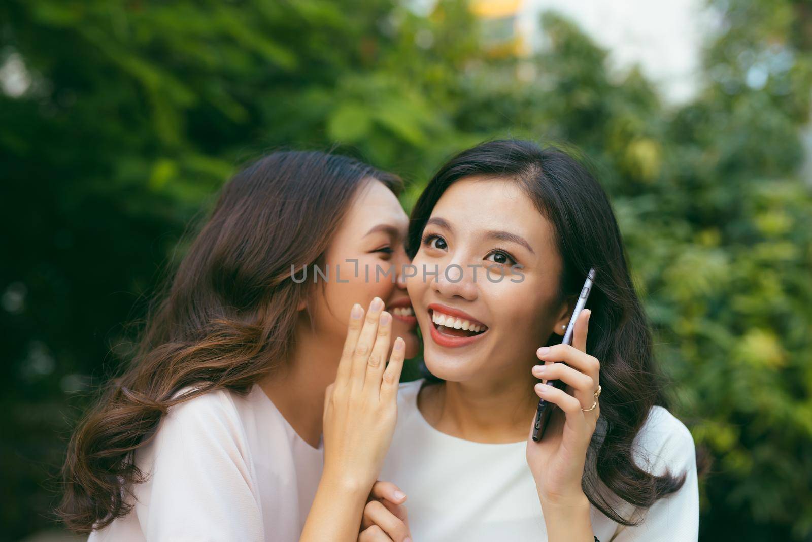 Two young women socializing outdoors. by makidotvn