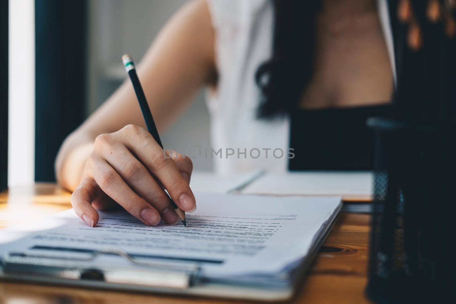 Close up business woman reading and signing contract.