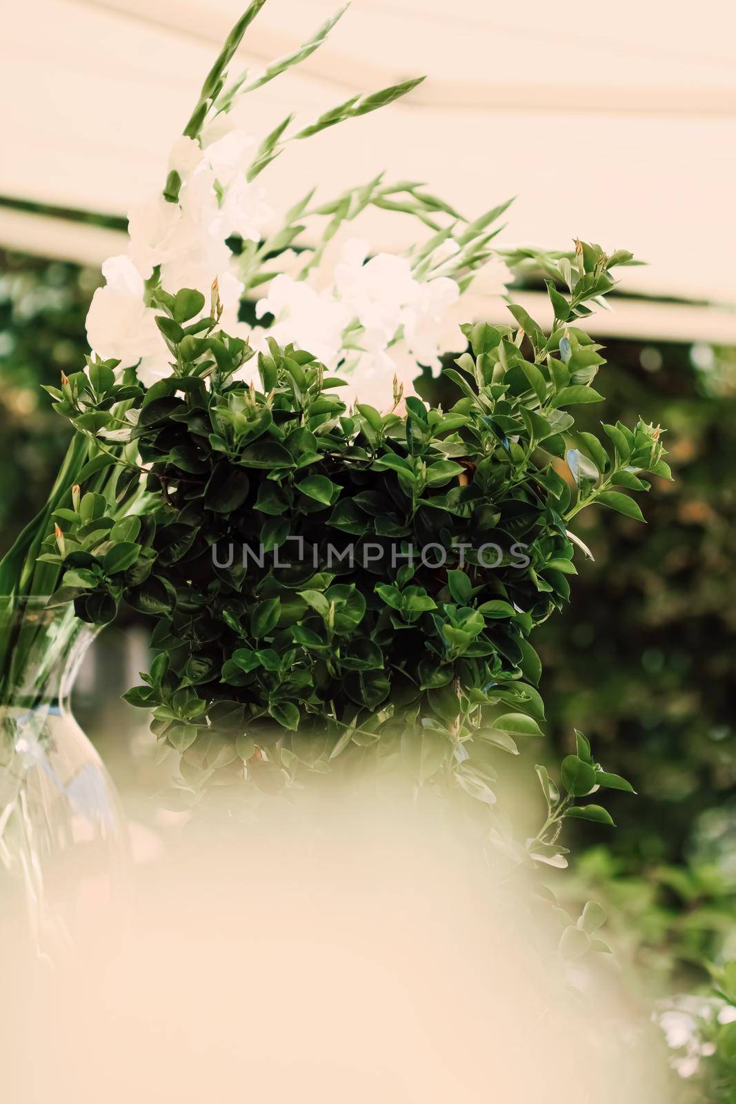 Floral wedding decoration in a restaurant outdoors in summer by Anneleven