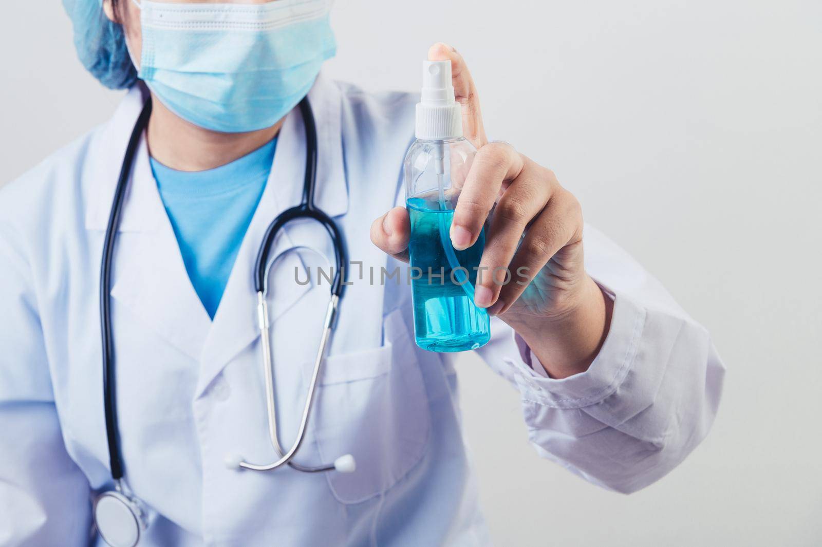 Doctor sprays hand sanitizer or gel dispenser to clean hands and kill viruses and bacteria into the air after patients visited. Medical health people and illness protective concept. 