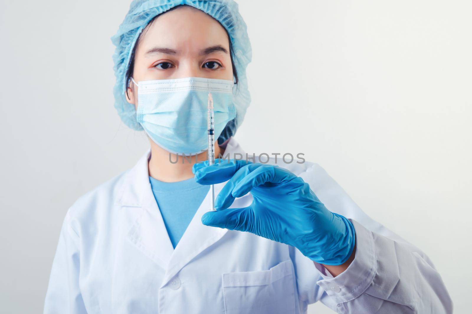 Closeup vial of covid-19 vaccine in hand of professional scientist or doctor in laboratory for treatment with mask gloves and lab coat on white background. Health business and industry concept. by MiniStocker