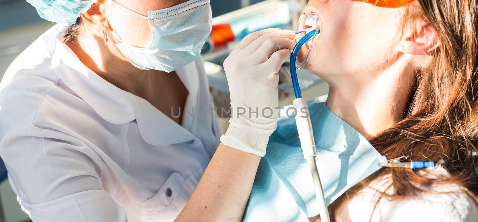 Woman dentist working at her patients teeth.