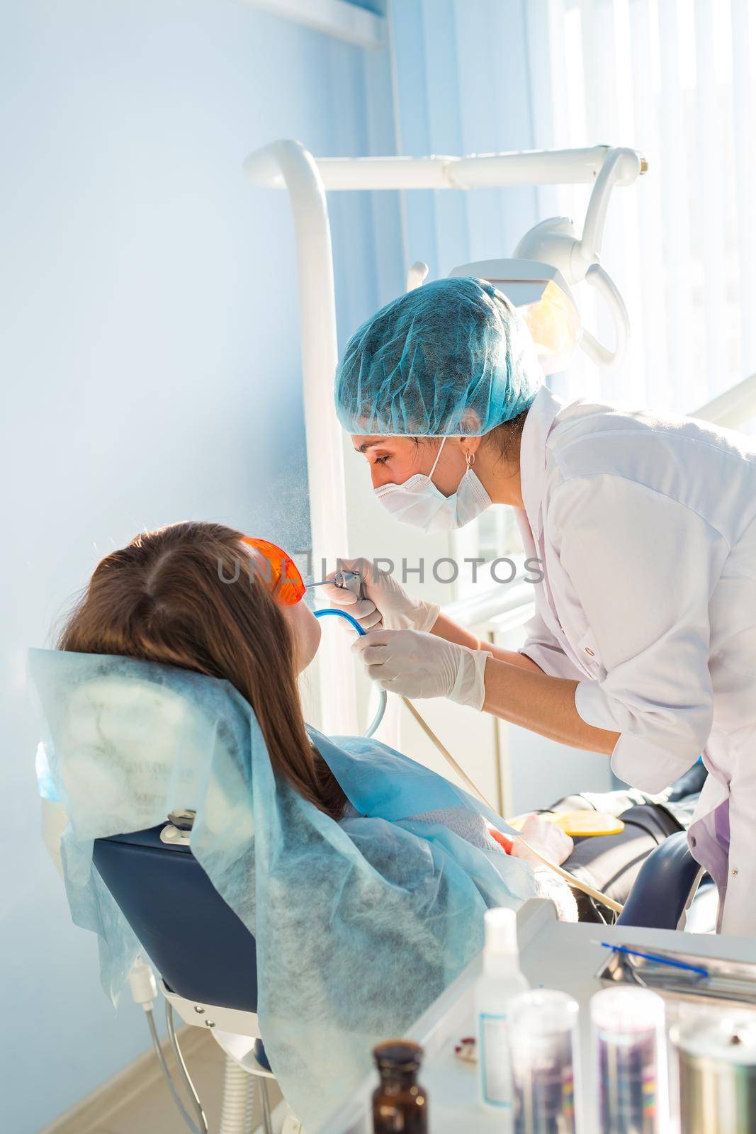 Woman dentist working at her patients teeth by Satura86