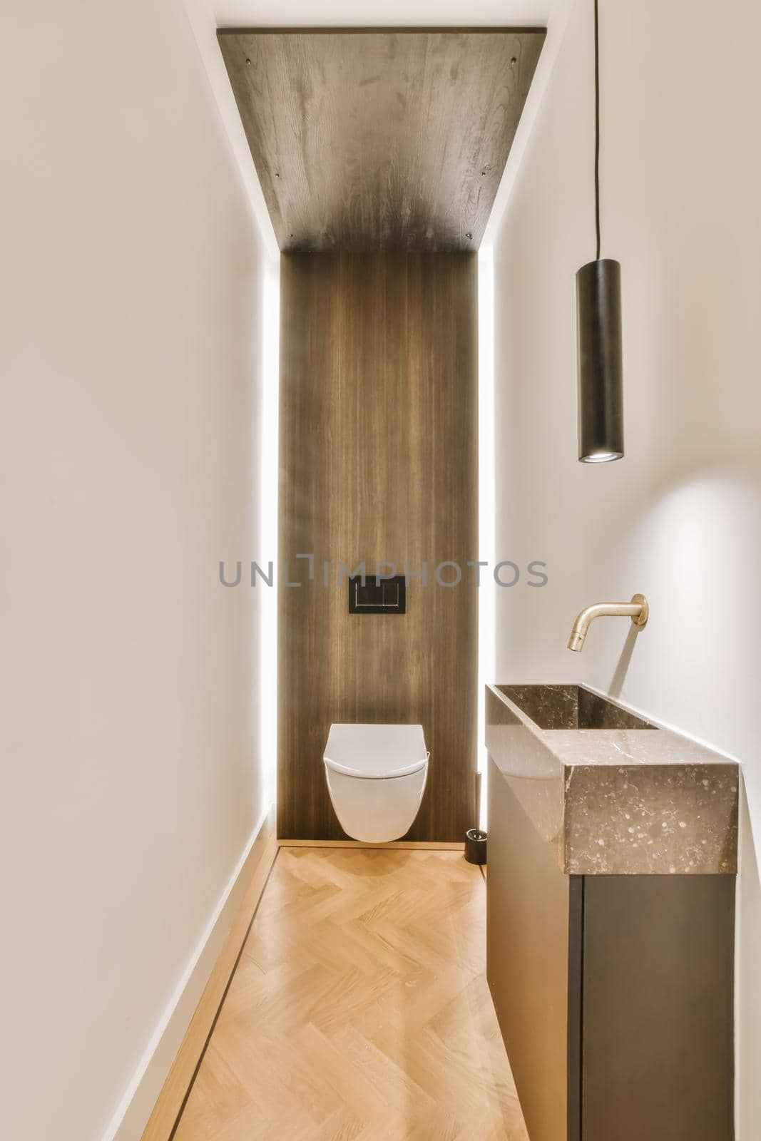 Long narrow lavatory with a wooden one wall and a small washbasin