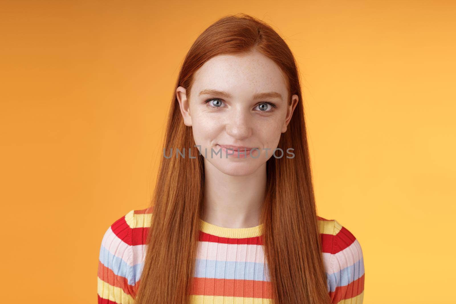 Attractive self-assured redhead girl encouraging herself look mirror confident prepare interview speech standing orange background smirking intrigued listening talking casually by Benzoix