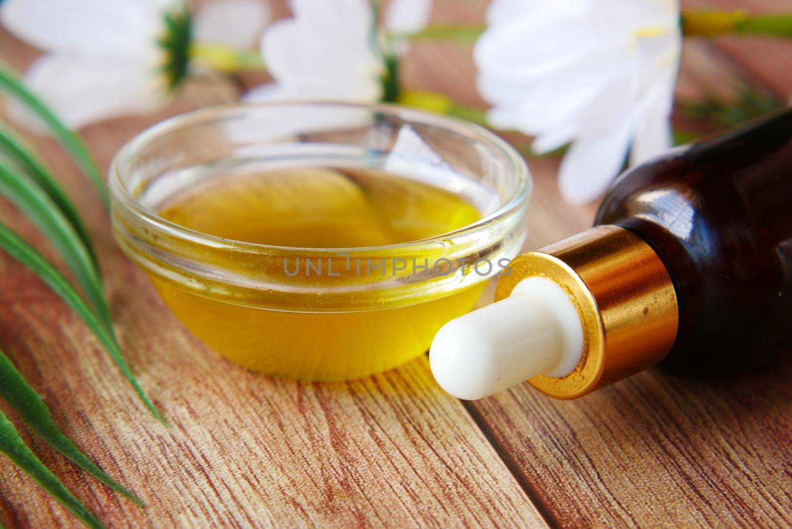 pipette and oil in a small container on table ,