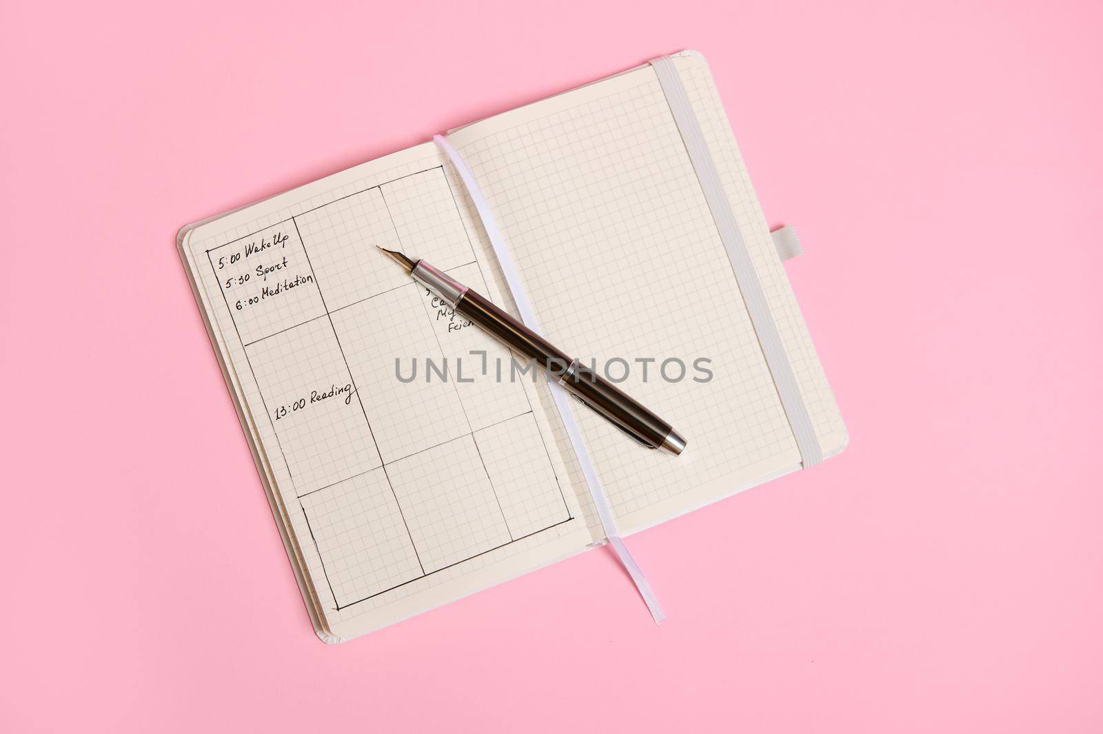 Flat lay of Planner templates and schedule of the day according to the hours marked in diary and with an ink pen lying on an open notebook. Business book diary, office organizer plans. Space for text