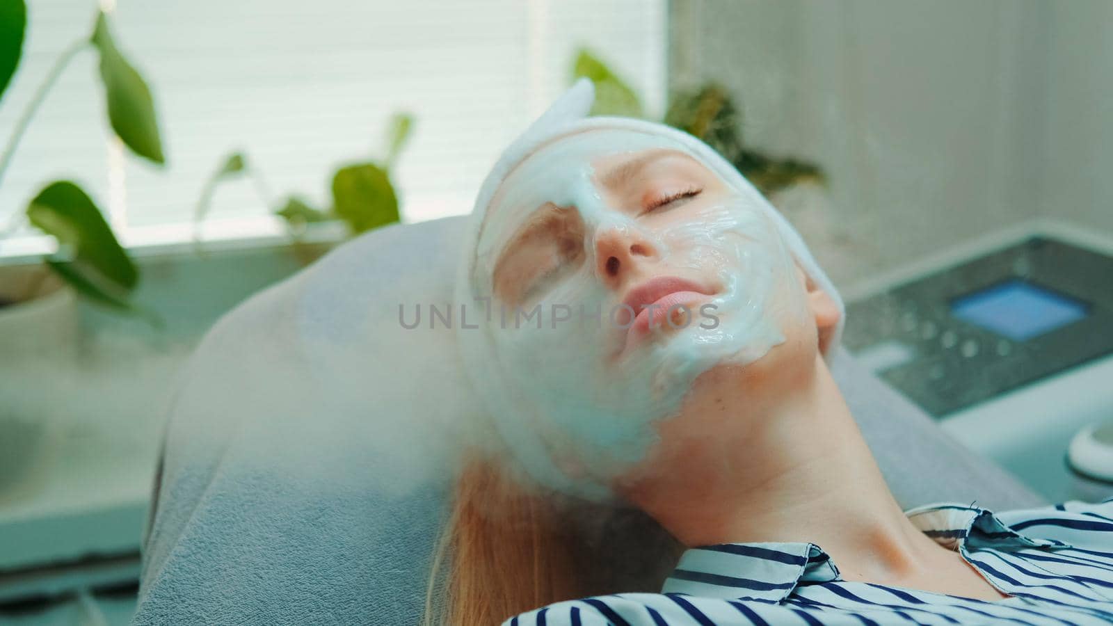 Medium close-up shot of professional facial skin care treatment with a cosmetic steamer at beauty salon. The Steam cleaning procedure of the face.