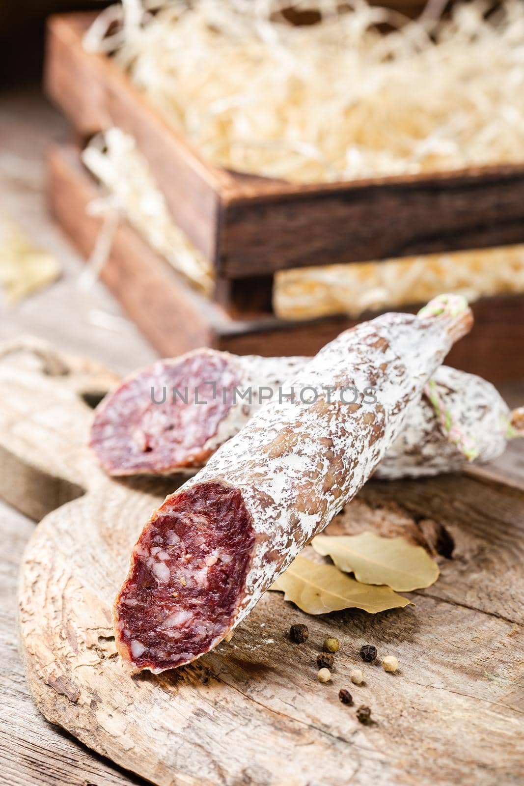 Smoked sliced salami on a old wooden table by Syvanych