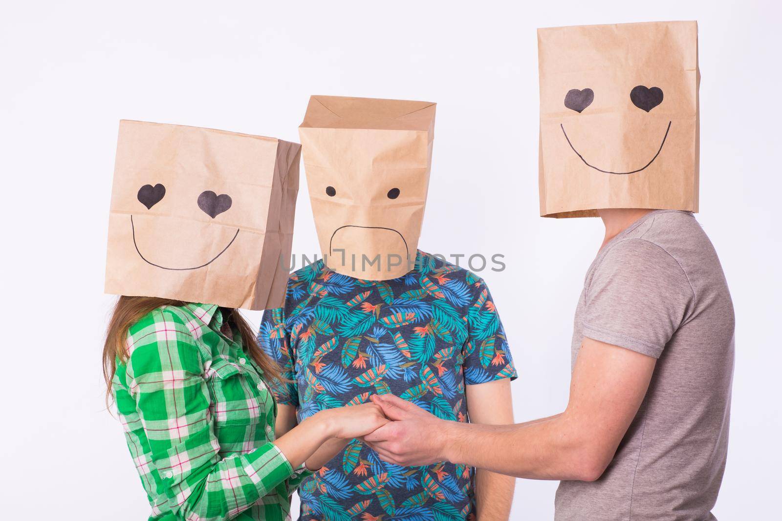 Love triangle, jealousy and unrequited love concept - woman and man with bags over heads holding hands and another man is angry. by Satura86
