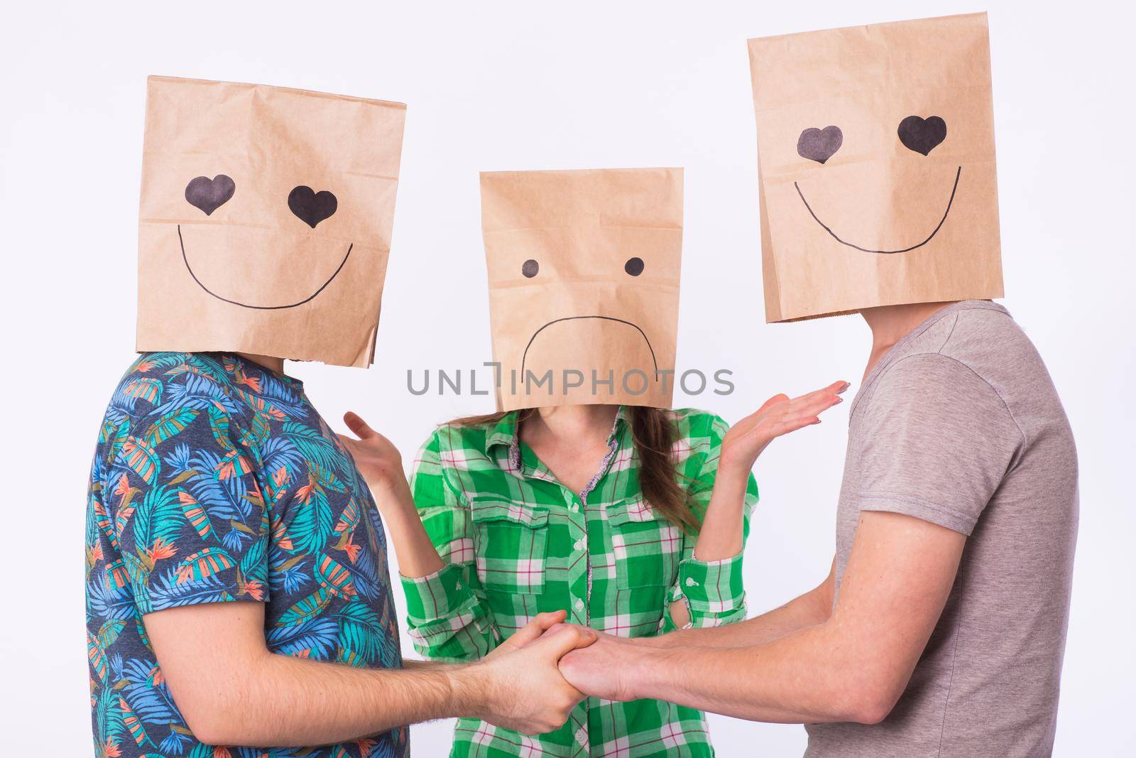 Love triangle, jealousy and homosexuality concept - gays with bags over heads holding hands and another woman is angry.